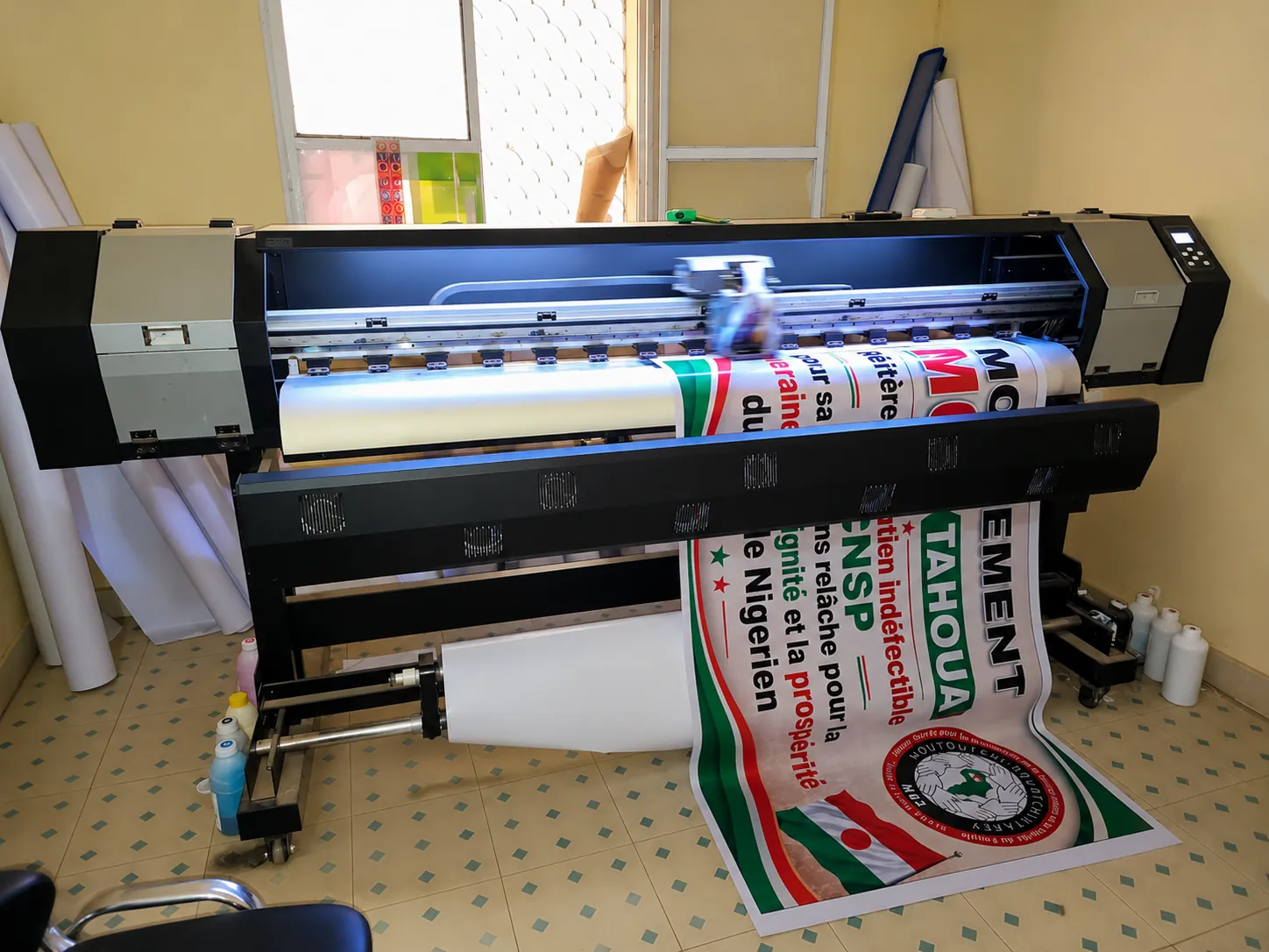 Imprimante grand format de l'atelier ETS Issoufou Impression produisant une bâche publicitaire